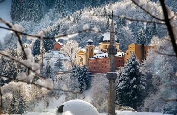 Зимний лес в Боснии на фоне замка и минарета