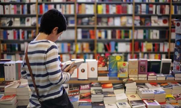 Девушка смотрит книгу в магазине