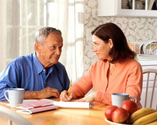 Пожилой мужчина и женщина оформляют документ