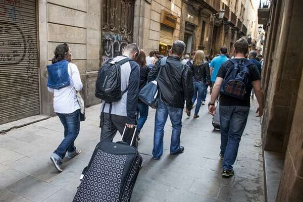 Люди с чемоданами идут по улице