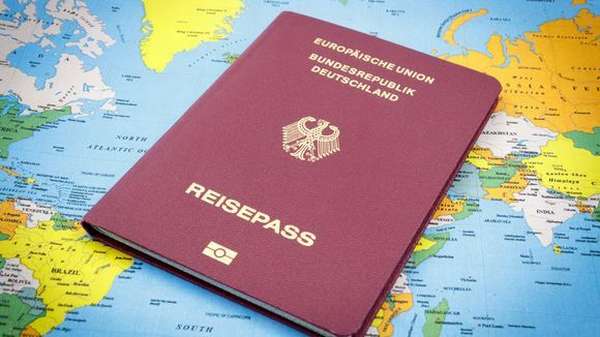 Паспорт гражданина Германии на фоне карты мира