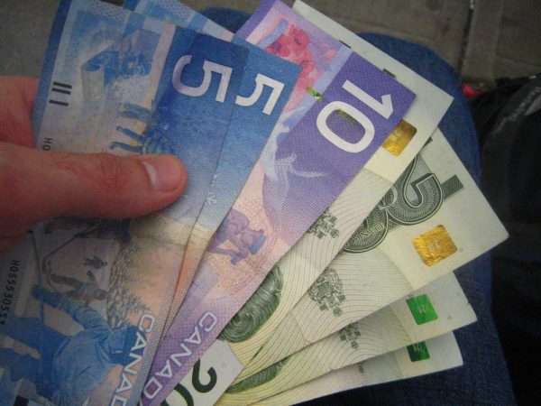Канадские доллары в руке