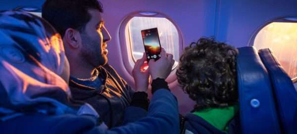 Пассажир в самолёте со смартфоне