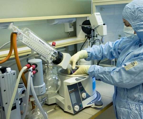 Медицинский сотрудник в маске работает со специализированным оборудованием