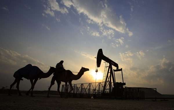 Погонщик верблюдов на фоне нефтяной вышки