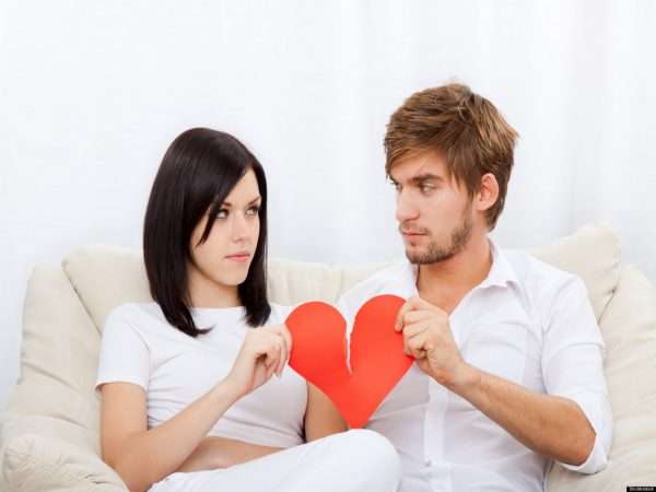 Мужчина и женщина делят бумажное сердце