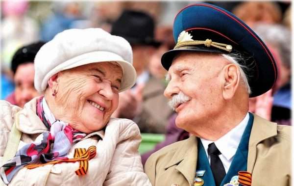 Пожилые мужчина и женщина улыбаются друг другу