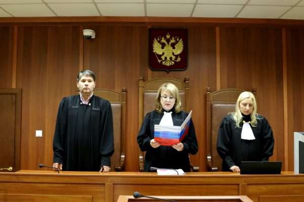 Трое судей в зале судебного заседания